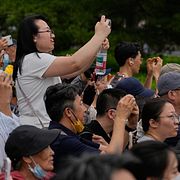 Människor fotograferar Trump och Xi i Kina.