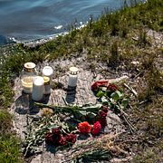 Blommor och ljus vid den badplats i Mölnlycke där en man i 45-årsåldern misshandlades till döds sent på lördagskvällen.