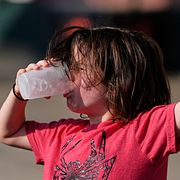 Ett barn dricker smält glass under förra årets värmebölja i USA.