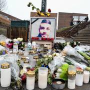 Blommor och ljus framför ett porträtt av den mördade 16-årige Ahmed Obaid. 