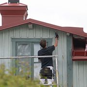 En hantverkare målar om fasaden på ett hus i staden Trosa.