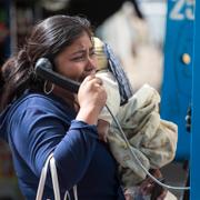 En anhörig till en av ungdomarna som bodde på hemmet talar i en telefonautomat tidigare i veckan, medan hon väntar på besked om namnen på dem som dött i branden. 