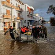 Poliser evakuerar människor i gummibåt.