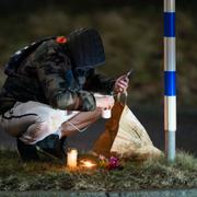 En man tänder ett ljus framför Risbergska skolan i Örebro på tisdagskvällen efter tisdagens skolskjutning som krävde ett tiotal liv. 