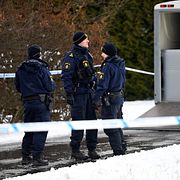 Polis utanför villan i samband med att de tre döda männen hittades.