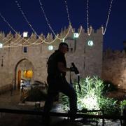 En polis vid attentatsplatsen utanför den norra ingången till Jerusalems gamla stad. 