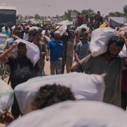 Palestinier bär mat och andra förnödenheter som delats ut i nödhjälp. 