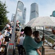 Folk som står framför Shanghais finansiella centrum. 