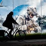 Man cyklar förbi reklam för vapentillverkaren Rheinmetall. 