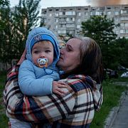 En kvinna bär ett barn i Kyiv efter nattens attacker.