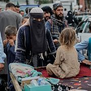 En kvinna och hennes barn säljer varor i Kabul. Illustrationsbild.