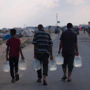 Män från ett flyktingläger i Dayr al-Balah hämtar vatten, 19 juli.