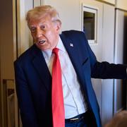 Donald Trump talar med reportrar ombord på Air Force One på väg hem från Storbritannien.