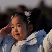 Ett barn viftar med den kinesiska flaggan under firandet av det kinesiska nyåret i Peking.
