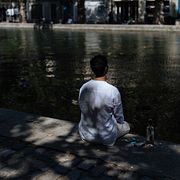 En man söker skydd i skuggan i Paris.