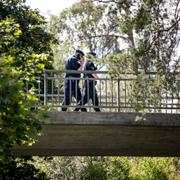 Poliser på gångbron i Flemingsberg där skottlossningen skedde.