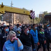 Människor utanför ett flerfamiljshus i Pryluky utanför Kyjiv som attackerades av Ryssland tidigare i veckan.