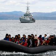 En flyktingbåt och en båt från Frontex utanför grekiska ön Lesbos