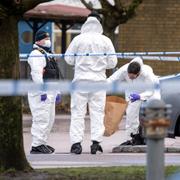 Kriminaltekniker och polis arbetar innanför avspärrningarna på en parkering vid Adolfsberg där mordet skedde 2024.