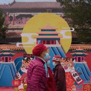 Elderly women wearing masks walk through a park on Friday, March 18, 2022, in Beijing