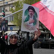 En kvinna håller upp en bild på Mojtaba Khamenei, som inte har synts till på mer än två veckor.