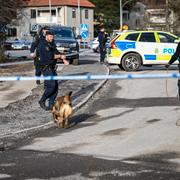 Polis med hund vid avspärrningar.
