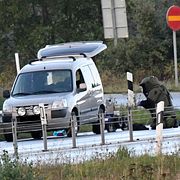 Polisens bombtekniker och bombrobot undersöker bilen. 