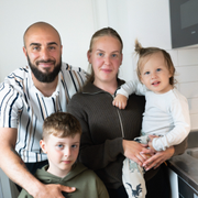 Familjen Hedlund, fotograferade i sin lägenhet. Till vänster en vattenmätare som registrerar hur mycket vatten som förbrukas. 