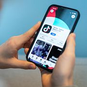 En användare tittar på Tiktok på telefonen. Illustrationsbild.