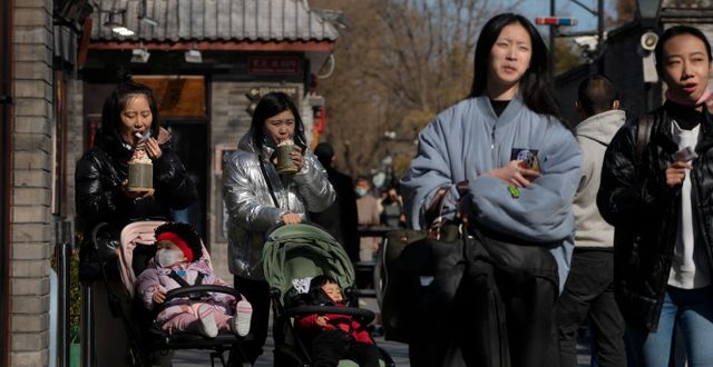 Kvinna med barn på en turistgata i Peking, 1 mars. Andy Wong / AP