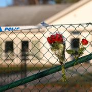 Blommor på stängslet utanför det vårdboende i Enköping där en ung kvinna i personalen dödades på torsdagen. 