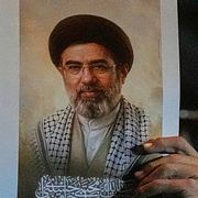 En irakier håller upp en porträttbild av Irans nye högsta ledare Mojtaba Khamenei i Bagdad på måndagen.