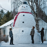 20-årige William bredvid sin snögubbe han byggt i Arvidsjaur.