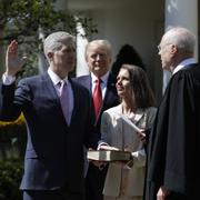 President Donald Trump tittar på när Neil Gorsuch svärs in. Hans fru Marie Louise Gorsuch håller i bibeln.