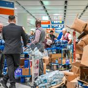 Mat och dryck delas ut till människor på flygplatsen under lördagsmorgonen.