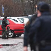 Poliser söker igenom parkeringsplatsen i närheten av polishuset i Uppsala i dag.