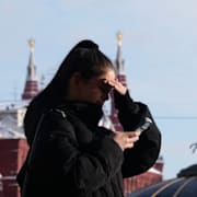 En kvinna tittar på sin mobil i centrala Moskva.
