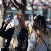 Kvinna med ansiktsmask i Kungsträdgården i Stockholm i mars.