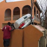 Arkivbild: En bil ligger upp och ner vid en byggnad i Anguilla. 