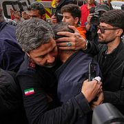 En räddningsarbetare tröstar en man som har förlorat en nära anhörig i Teheran, 27 mars.