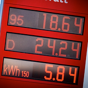 Bensinpris på 18,64 kr per liter och dieselpris på 24,24 kr per liter på skylten på en bensinmack i Kristianstad 20 mars. Till höger: Fartyg väntar utanför Förenade Arabemiraten på att kunna passera Hormuzsundet.