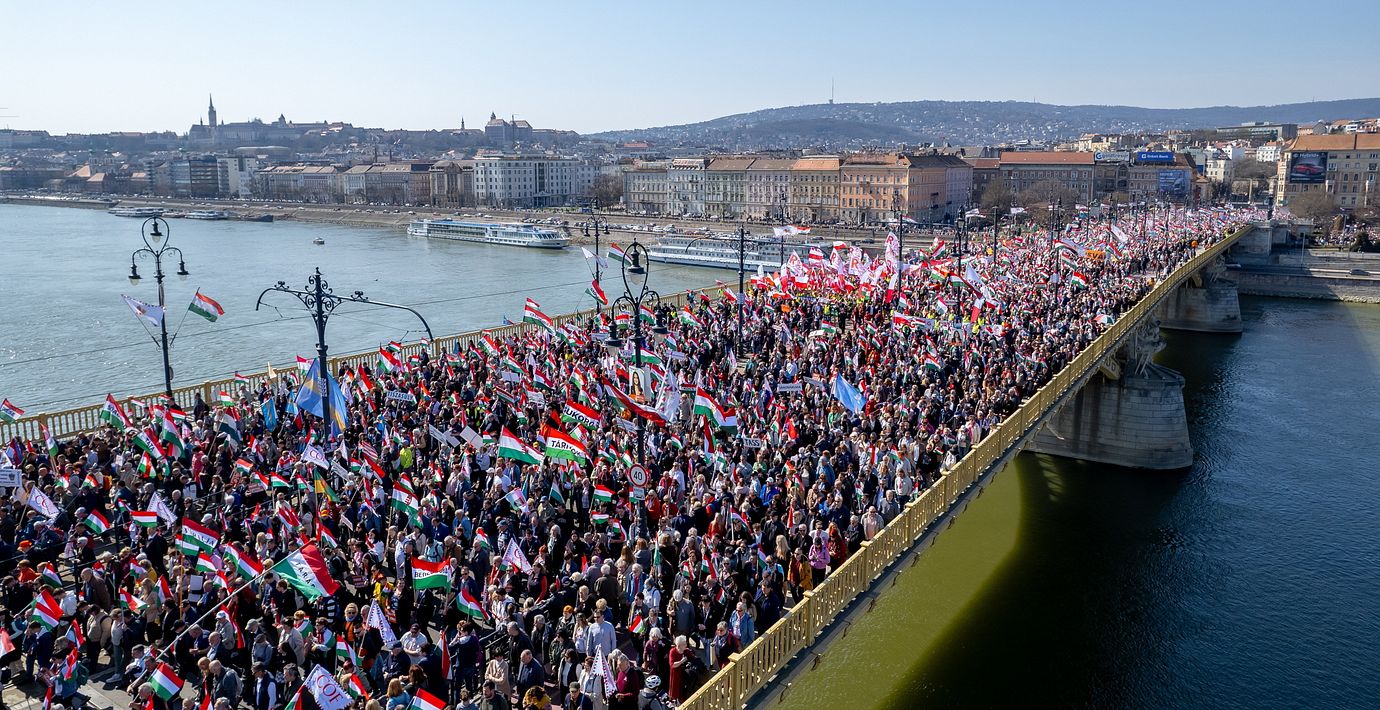 Demonstranter som stödjer regeringen marscherar över en bro i Budapest.