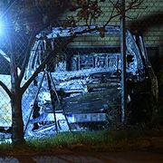 Polisens kriminaltekniker undersöker den utbrända bilen.