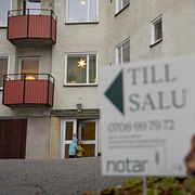 Mäklarskylt framför ett bostadshus. Arkivbild.