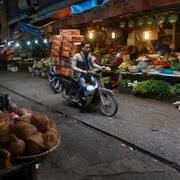 En man transporterar paket på baksidan av hans motorcykel vid en marknad i Hanoi. Arkivbild.