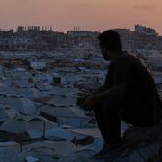 En man blickar ut över ett bombat område i Gaza City, 25 juli.