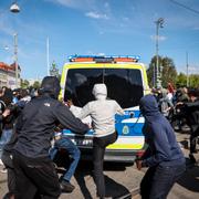 Demonstranter attackerar polisbil under demonstrationen.