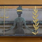 Fru Justitia ovanför ingången till säkerhetssalarna vid Stockholms tingsrätt.