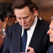 Elon Musk använder sin telefon vid installationen.