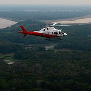 En helikopter flyger över Amazonas regnskog i Brasilien.